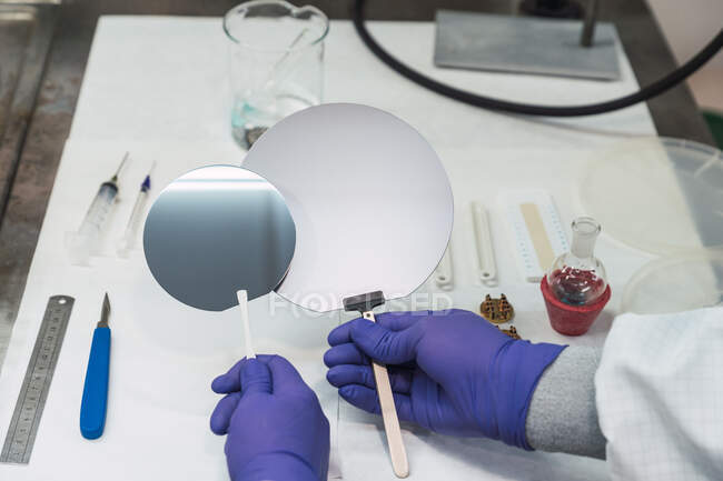 Эксперты лаборатории без растениеводства в латексных перчатках показывают круглые зеркала над столом в лаборатории — стоковое фото