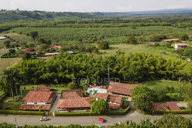 Aerial top view of contemporary hotel houses with outdoor swimming pool surrounded by verdant tropical greenery in Armenia Colombia — Stock Photo