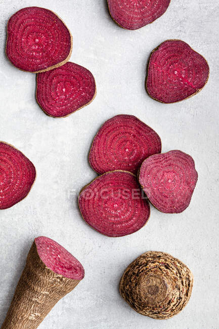 Overhead composition of organic natural beetroot cut into slices and arranged on white surface — Stock Photo