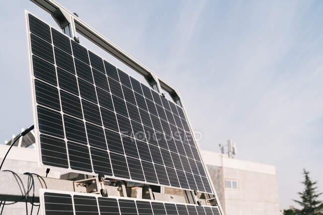 Современная фотоэлектрическая панель установлена на солнечной электростанции под голубым небом в солнечный день — стоковое фото