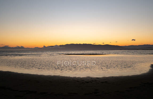 Ruhige Meereslandschaft am Sandstrand nahe ruhigem Meer bei Sonnenuntergang — Stockfoto