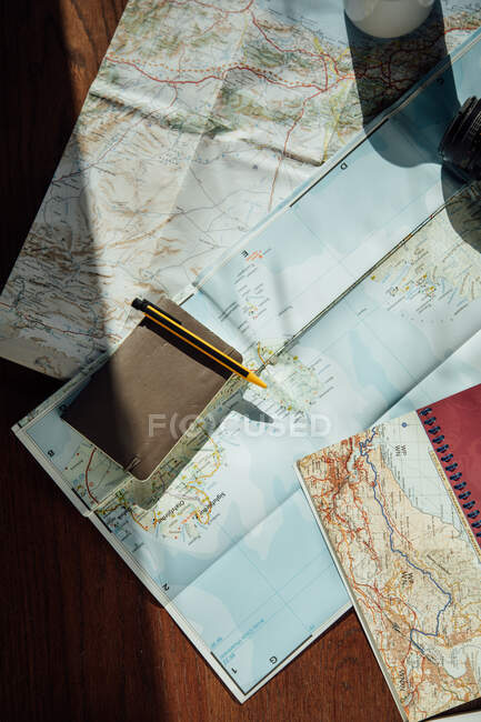 Top view of route map during trip with notepad and pen on wooden table - foto de stock