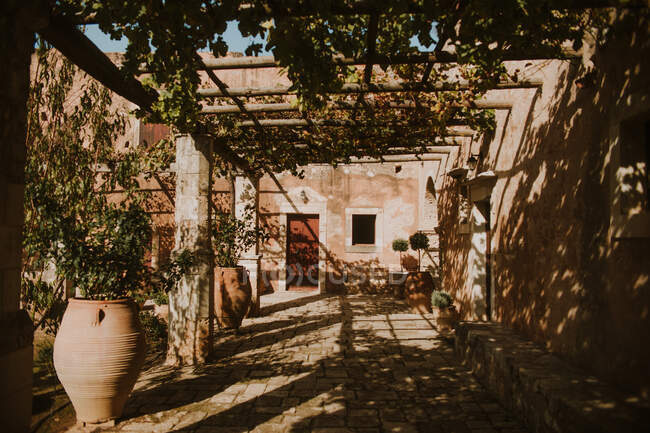 Patio médiéval du monastère Arkadi aux murs abîmés et décoré de verdure sur un temps ensoleillé en Crète Grèce — Photo de stock