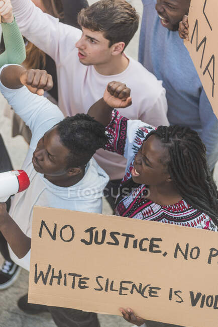 Сверху толпы многорасовых людей с плакатами, кричащими во время демонстрации черной жизни, имеют значение в городе — стоковое фото