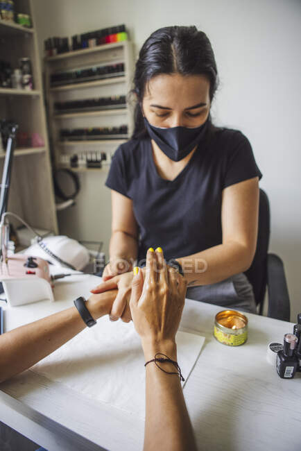 Manicurist massaging hands of faceless client after applying cosmetic oil in nail studio — Foto stock