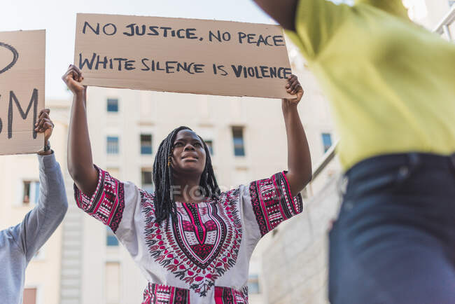 Low angle of African American woman protesting with posters during Black Lives Matter demonstration in city — Photo de stock