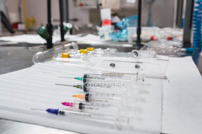 Состав стерильных медицинских шприцов разных размеров, расположенных на столе в больнице — стоковое фото