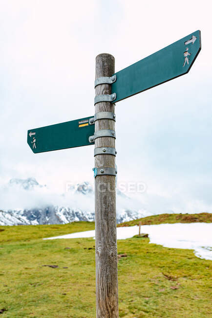 Low angle of direction pole with simple boards showing directions of footpaths for hikers in Peaks of Europe — Stock Photo