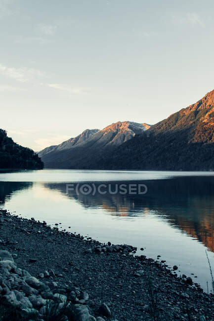 Cenário espetacular de gama montesa com floresta verde localizada perto de lago calmo com água ondulante — Fotografia de Stock