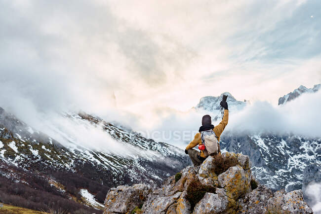Voltar ver turista feminino com mochila segurando câmera fotográfica enquanto fotografa incrível natureza de Peaks da Europa durante a viagem — Fotografia de Stock
