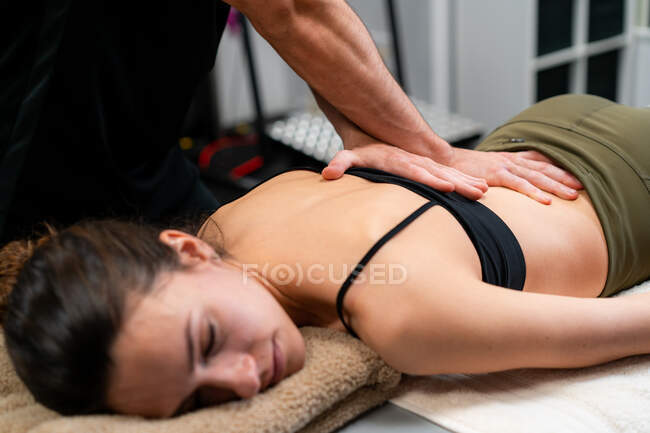 Ernte männliche Physiotherapeut massiert Rücken der Frau auf Bett während medizinischer Behandlung im Krankenhaus — Stockfoto
