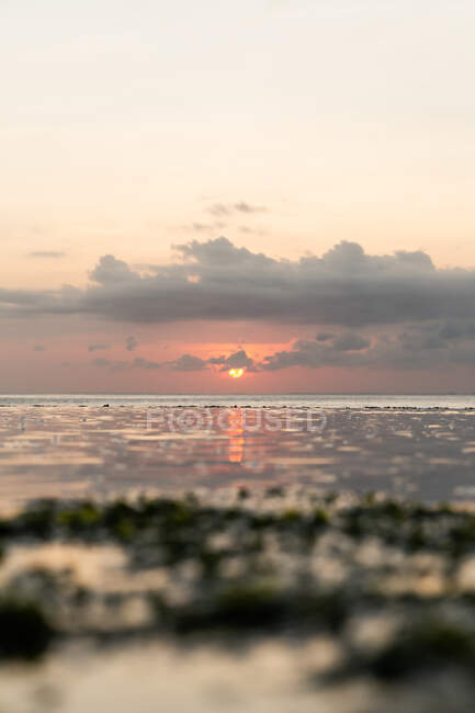 Vista pitoresca do céu brilhante do pôr-do-sol sobre ondulação mar calmo em natureza pacífica — Fotografia de Stock