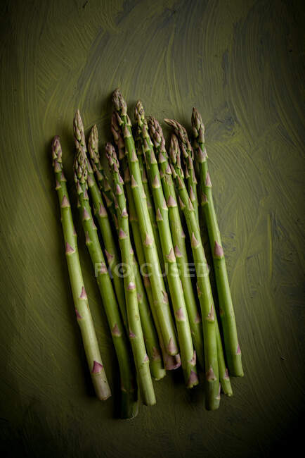 Vista dall'alto di mucchio di steli di asparagi crudi con superficie irregolare e bordi ondulati — Foto stock