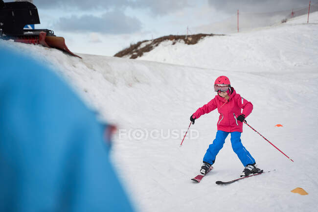Gesichtslose Eltern in warmer Sportkleidung bringen kleinen Kindern das Skifahren entlang der schneebedeckten Schanze im Winterskigebiet bei — Stockfoto