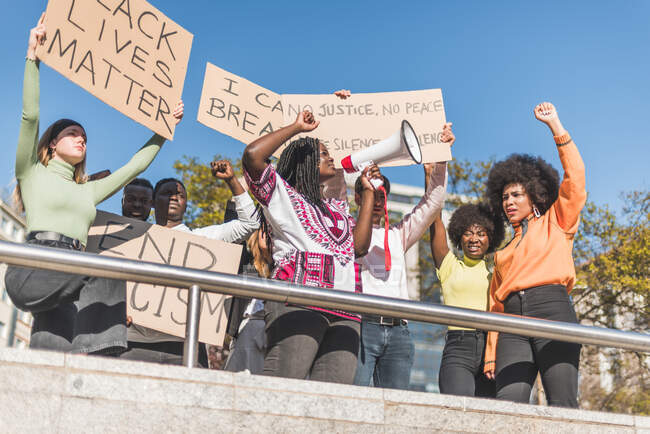 Von unten von der Menge der multirassischen Demonstranten mit Plakaten und Megafon, die während des Protests der Schwarzen auf der Straße stehen — Stockfoto