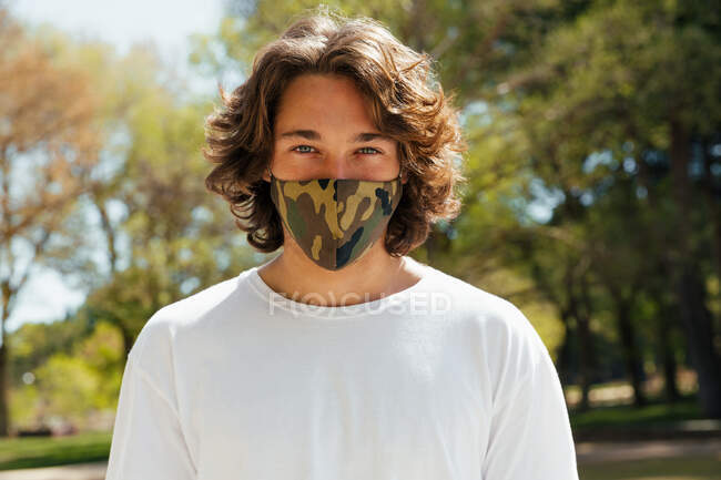 Junger Mann mit Maske blickt in die Kamera — Stockfoto
