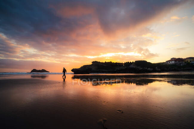 Uomo irriconoscibile che si gode un tramonto sul mare in una giornata estiva — Foto stock