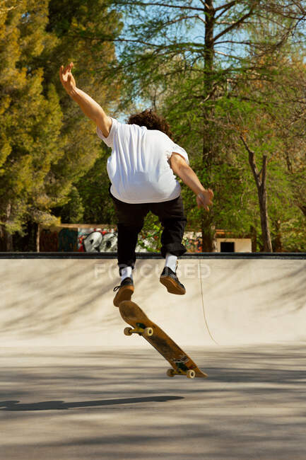 Back view of skater jumping on his board — Stock Photo