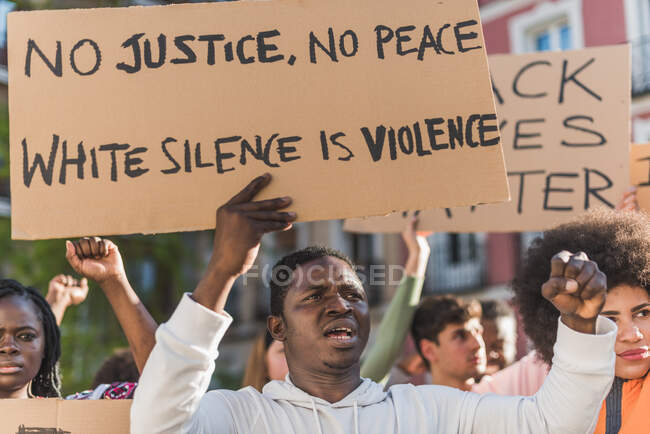 Crowd of multiracial people with Black Lives Matter poster protesting together on city street against racial discrimination — Stock Photo