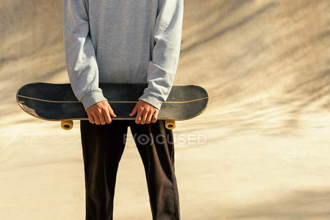 Close-up of a young man holding his worn board — Stock Photo