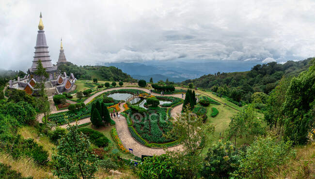 From above of aged oriental shrines among walkways with trees and pond under cloudy sky in Chiang Mai Thailand — Stock Photo