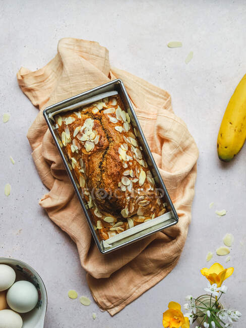 Blick von oben auf köstlichen Kuchen mit süßen Mandelflocken im Metallbacken von Serviette auf den Tisch gelegt — Stockfoto