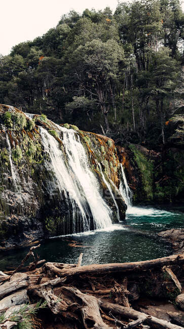 Vista espetacular do poderoso fluxo de cachoeira que flui no lago na floresta montanhosa — Fotografia de Stock