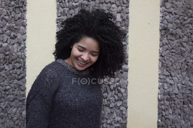 Erfreut ethnische Frau mit Afro-Frisur, die auf der Straße steht, während Blick nach unten — Stockfoto