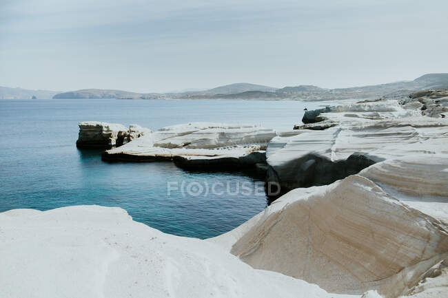 Scenic view of rough stony shore near blue rippling sea in sunny Sarakiniko Greece — Stock Photo