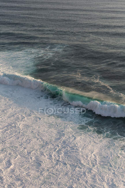 Onde di mare schiumose rotolano sotto il cielo blu in Indonesia nella giornata di sole — Foto stock