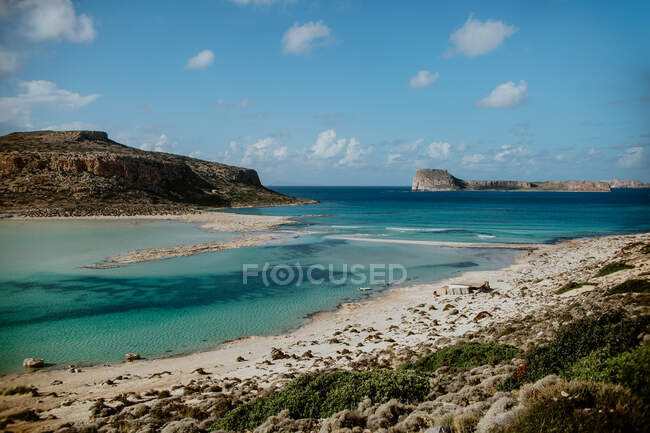 Erstaunliche Landschaft von türkisfarbener Meeresbucht, die felsige Klippen und sandigen Strand von Balos unter wolkenlosem blauen Himmel spült — Stockfoto