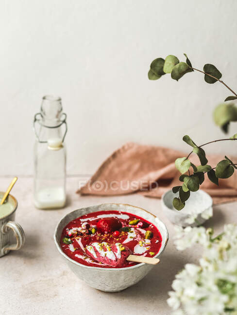 De cima de batido saboroso com bagas frescas e doces de gelo com pistache esmagado e iogurte em tigela — Fotografia de Stock