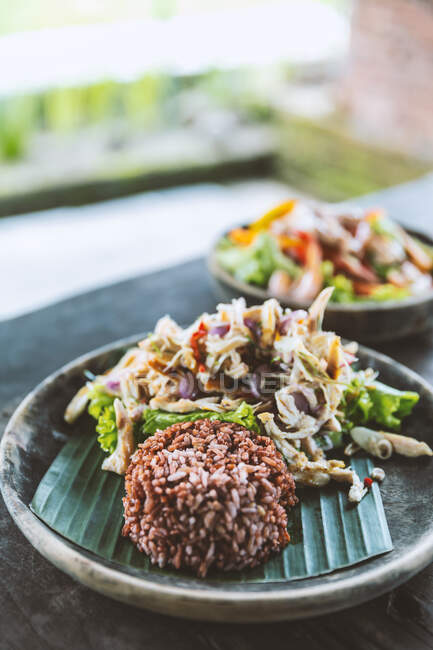 Appetizing black rice served with delicious tofu salad and vegetables in outdoor restaurant — Stock Photo