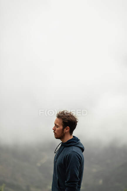 На схилі видніється дбайливий подорожній - самець, що стоїть на вершині гори в Севільї в туманну погоду. — стокове фото