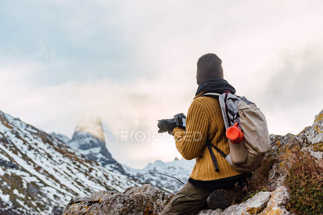 Vista lateral turista feminina com mochila usando câmera fotográfica enquanto fotografa incrível natureza de Peaks da Europa durante a viagem — Fotografia de Stock