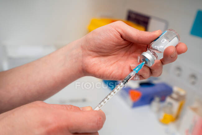 Cultivé vétérinaire femelle méconnaissable prenant des médicaments avec injecteur de bouteille — Photo de stock