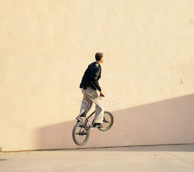 З боку молодого афроамериканського спортсмена, який виконує трюк на пробному велосипеді в скейт-парку в місті — стокове фото