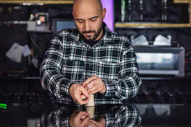 Uomo che prepara narghilè tradizionale con lamina di metallo in un night club — Foto stock