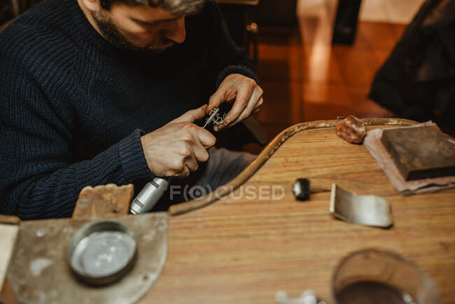 Ювелір використовує професійну полірувальну машину на верстаті при виготовленні металевого кільця в майстерні — стокове фото
