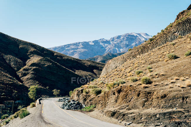 De cima de estrada de enrolamento de asfalto vazio em colinas marrons poderosas em dia ensolarado em Marrocos — Fotografia de Stock