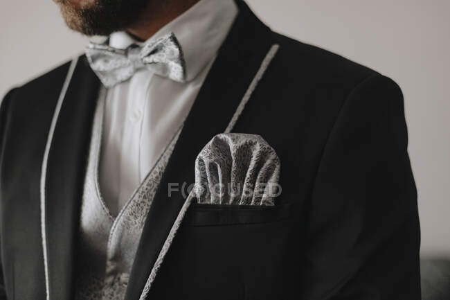 Crop anonymous bearded groom in stylish wedding tuxedo with bow tie and elegant pocket handkerchief — Stock Photo