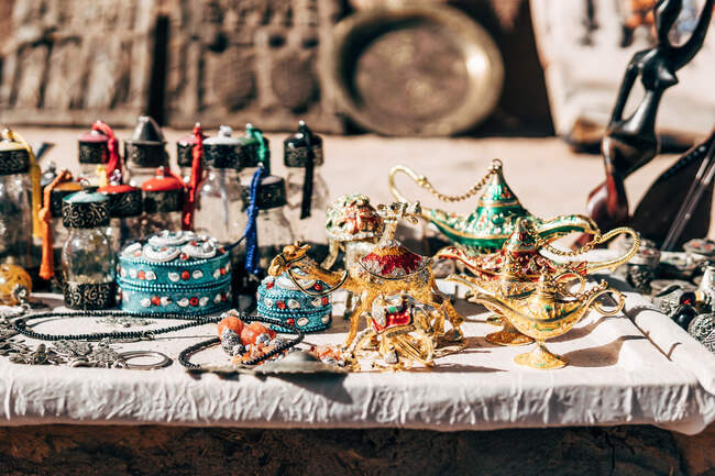 Desde arriba de coloridas lámparas de aceite cajas ornamentales y botellas de vasos colocados en la mesa en Marruecos - foto de stock