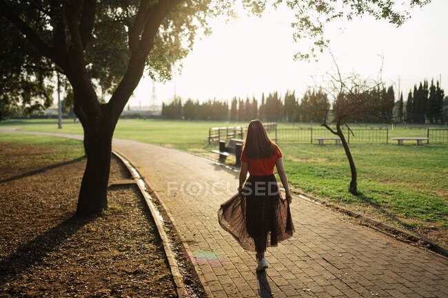 Модна жінка в літньому вбранні, стоячи на стежці в саду — стокове фото