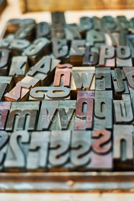 Vista superior do conjunto de letras de impressão de metal gasto colocado em caixa de madeira em tipografia — Fotografia de Stock
