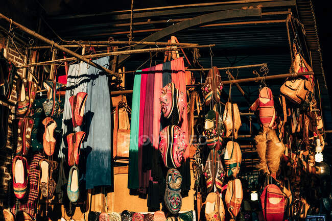 Zapatillas y pañuelos colgando en el puesto de calle en Marruecos — Stock Photo