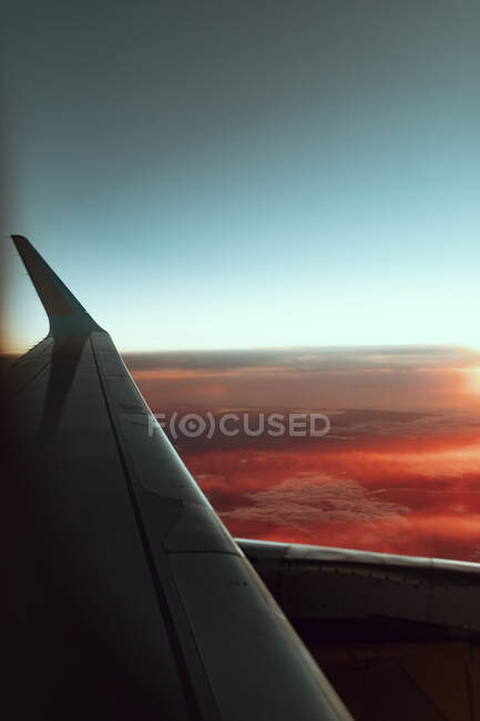 Vista pitoresca da asa da aeronave no ar perto do maravilhoso céu azul ao pôr do sol — Fotografia de Stock