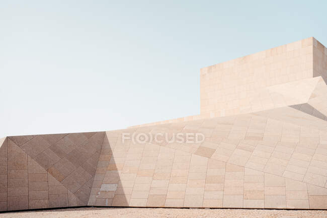 Внешний дизайн современной бетонной конструкции с геометрическими угловыми стенами против голубого неба — стоковое фото