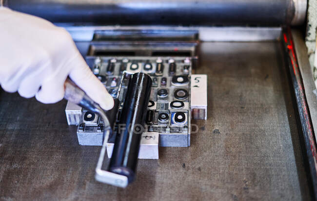 Зверху врожаю невизначений працівник з розписом металевих літер під час роботи в типографії — стокове фото