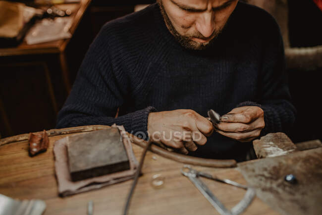 Juwelier mit professioneller Poliermaschine auf Werkbank bei der Herstellung von Metallringen in der Werkstatt — Stockfoto