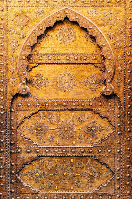 Vieille porte massive dorée avec ornement exotique traditionnel dans un ancien beau temple au Maroc — Photo de stock